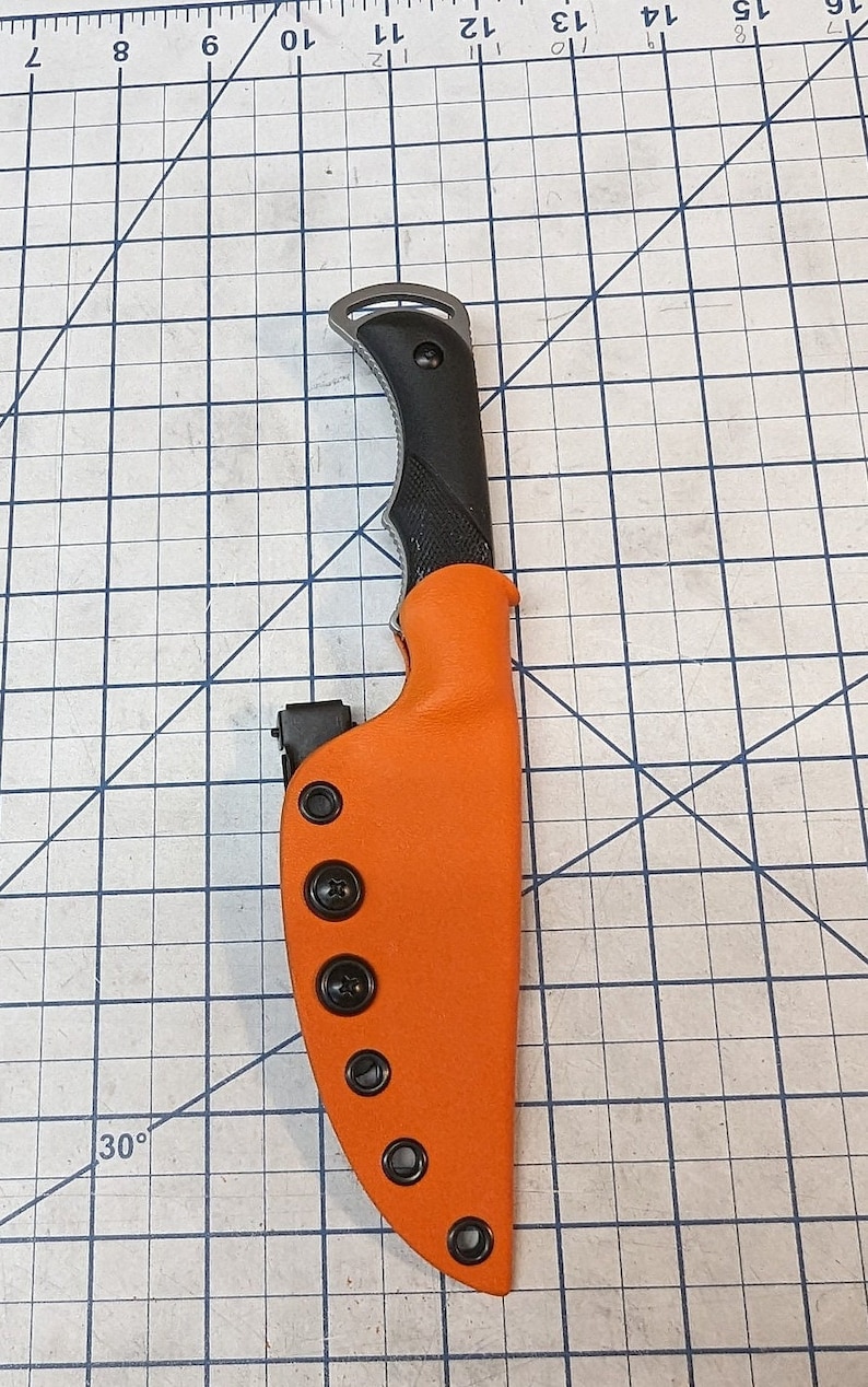 May include: A bright orange knife sheath with black snaps and a black knife with a black handle.