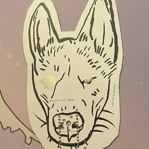 May include: Black and white line drawing of a dog's face with a gold metallic background. The dog is looking directly at the viewer with its mouth open and tongue sticking out. The drawing is on a white paper background.