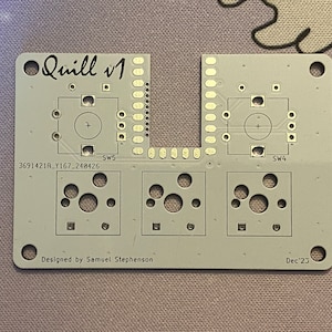 Może przedstawiać: Szara płytka drukowana z tekstem "Quill v1" i "Designed by Samuel Stephenson" oraz "Dec '23". Płytka ma kilka otworów i kilka małych kwadratów.