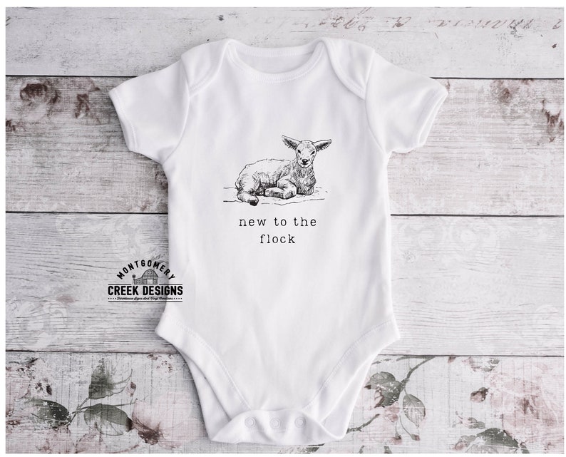 May include: White baby onesie with a black and white illustration of a lamb and the text "new to the flock".