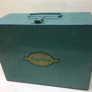 May include: A green metal box with a handle and a label that reads "Bacharach Instruments Co. Fyrite Test Kit Pittsburgh, PA, USA."