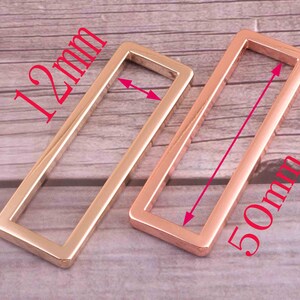 May include: Two gold-colored metal rectangular rings. The larger ring measures 50mm in length and the smaller ring measures 12mm in length.