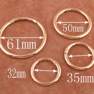 May include: Four gold-toned metal rings with different diameters. The rings are 61 mm, 50 mm, 35 mm, and 32 mm in diameter.