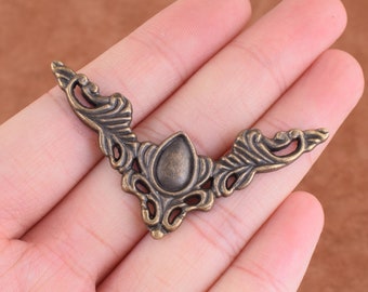 Può includere: Supporto d'angolo in metallo decorato con un design decorativo. Il supporto è in metallo bronzo scuro e presenta un motivo floreale.