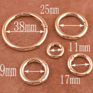 May include: Five gold-toned metal key rings of different sizes. The largest ring measures 38 mm in diameter, the next largest measures 25 mm, the next measures 19 mm, the next measures 17 mm, and the smallest measures 11 mm.