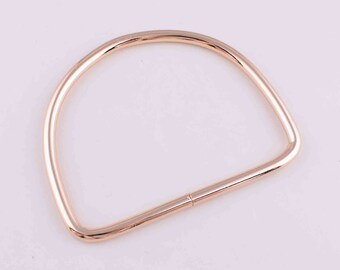 May include: A gold-toned metal D-ring handle for a bag or purse.