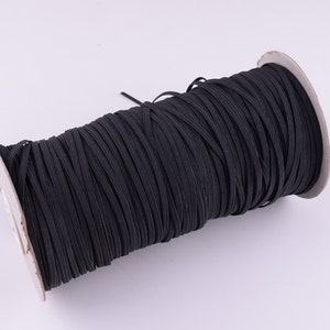 May include: A spool of black elastic cord, wound tightly on a cardboard core.