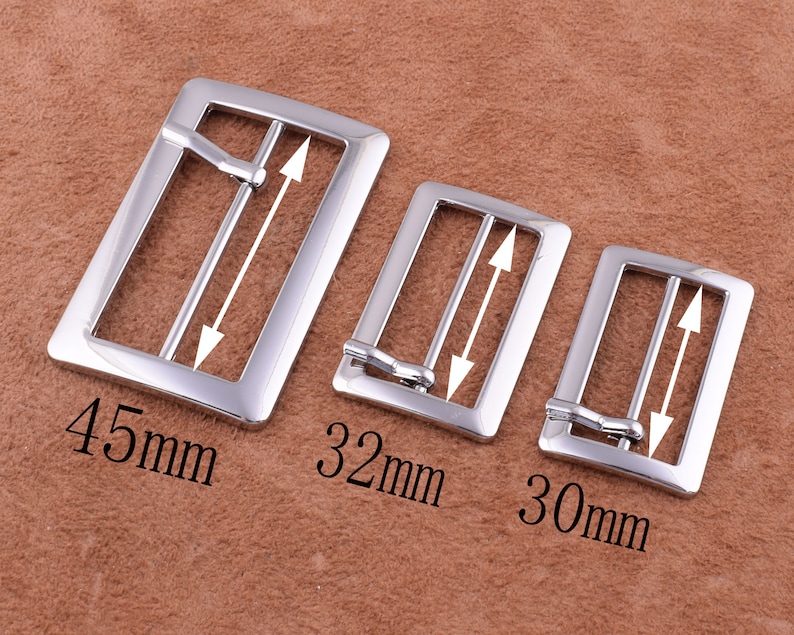 May include: Three silver metal belt buckles of different sizes. The largest buckle is 45 mm wide, the middle buckle is 32 mm wide, and the smallest buckle is 30 mm wide.