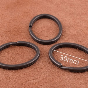 Peut inclure: Trois anneaux de clés en métal noir. Un anneau de clés a un diamètre de 30 mm.