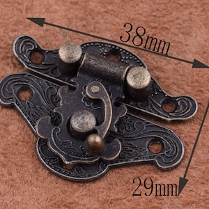 May include: Antique-style brass latch with ornate floral design. The latch measures 38 mm by 29 mm.