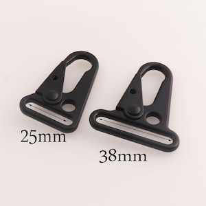 Puede incluir: Dos ganchos de cierre de gatillo de metal negro con un anillo en D. El gancho más grande mide 38 mm y el más pequeño 25 mm.