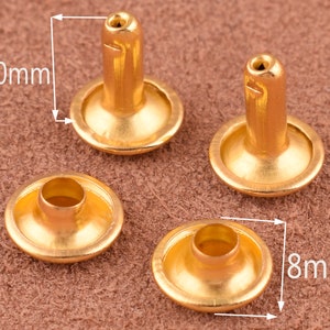 May include: Four gold-colored metal rivets, two with a 10mm diameter and two with an 8mm diameter. The rivets have a round head and a cylindrical post.