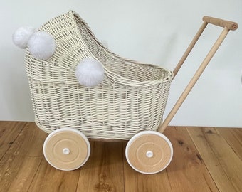 Carrozzina per bambole in vimini fatta a mano, color crema, con pompon e biancheria da letto