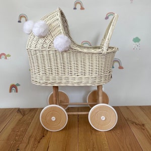 Wicker pram with bow, tall dolls pram, bow and bedding included. Cream/ off white pram with white pom-poms and bedding of your choice.