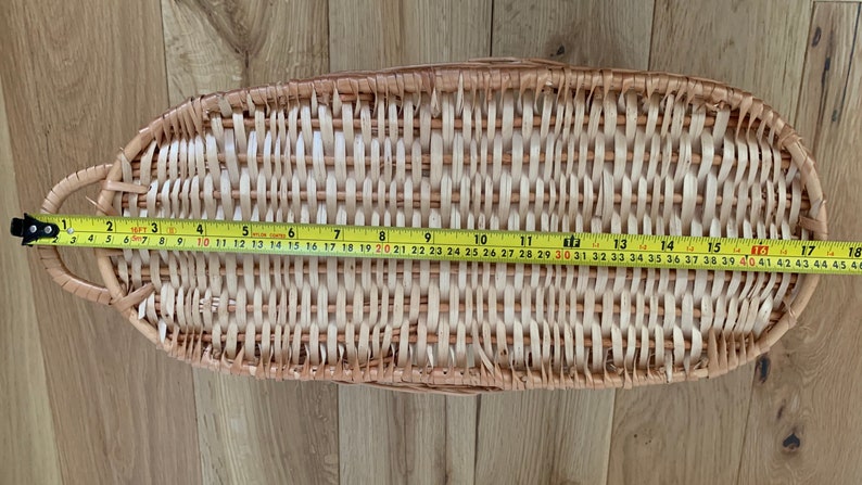 Pu&ograve; includere: Un cesto in vimini intrecciato di colore marrone chiaro con una finitura naturale. Il cesto &egrave; di forma ovale e misura 116,84 centimetri di lunghezza.