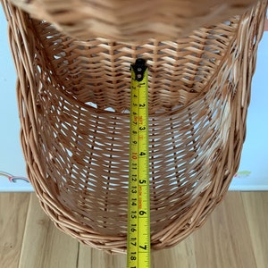 Pu&ograve; includere: Un cesto appeso in vimini marrone con un metro a nastro giallo che misura 18 cm di altezza.
