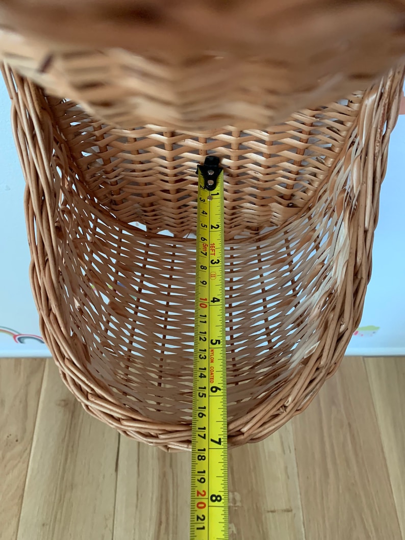 Pu&ograve; includere: Un cesto appeso in vimini marrone con un metro a nastro giallo che misura 18 cm di altezza.