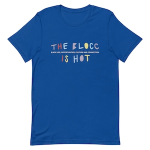 Op de afbeelding: Een koninklijk blauw T-shirt met de tekst "THE BLOCC IS HOT" in kleurrijke letters. De tekst "BLACK LIFE, OPPORTUNITIES, CULTURE AND CONNECTION" staat in kleinere letters onder de hoofdtekst.