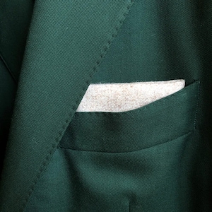 A photo of a set of three high quality wool pocket squares for men. The pocket squares are in shades of brown, camel and cream.