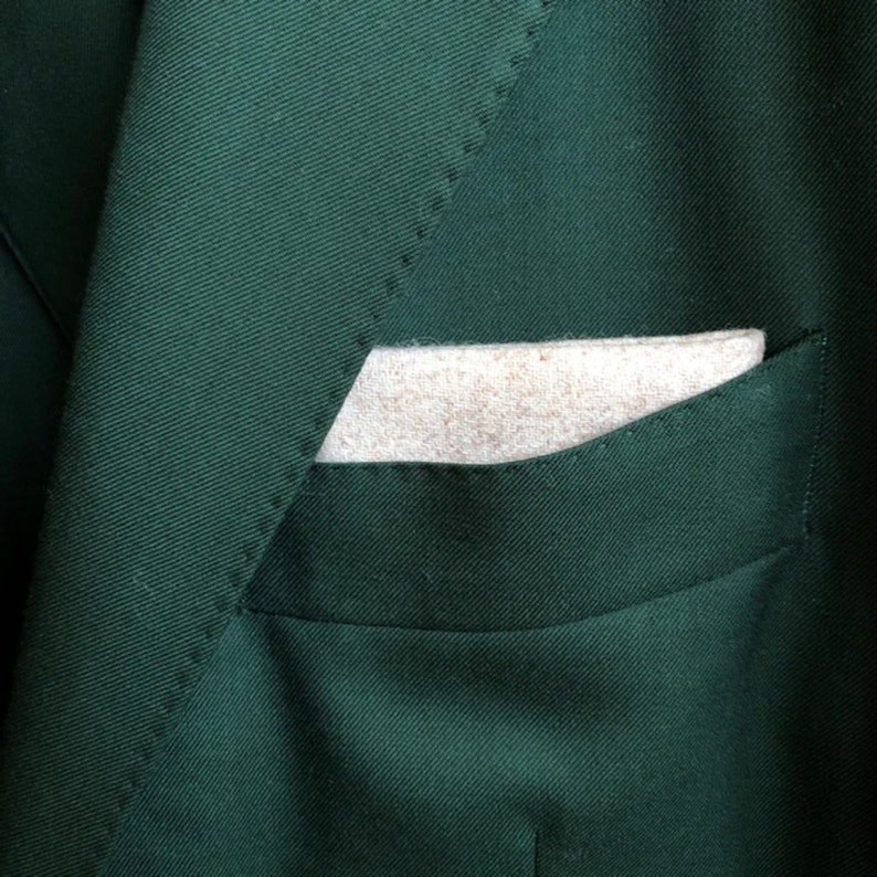 A photo of a set of three high quality wool pocket squares for men. The pocket squares are in shades of brown, camel and cream.