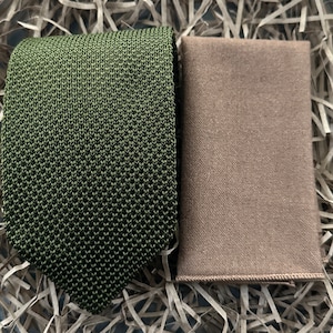 Peut inclure: Une cravate en tricot verte et un mouchoir de poche marron. La cravate a un motif texturé et le mouchoir de poche est uni.