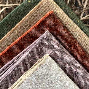 K&ouml;nnte beinhalten: Nahaufnahme von Stoffmustern in verschiedenen Farben. Die Muster umfassen Gr&uuml;nt&ouml;ne, Beige, Orange, Lila und Braun. Jedes Muster hat eine strukturierte Oberfl&auml;che und einen kontrastierenden Rand. Die Stoffe sind diagonal angeordnet.