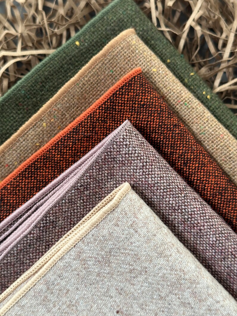 K&ouml;nnte beinhalten: Nahaufnahme von Stoffmustern in verschiedenen Farben. Die Muster umfassen Gr&uuml;nt&ouml;ne, Beige, Orange, Lila und Braun. Jedes Muster hat eine strukturierte Oberfl&auml;che und einen kontrastierenden Rand. Die Stoffe sind diagonal angeordnet.