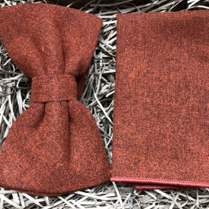 A photo of a burnt orange, cotton mens bow tie and a matching pocket square ideal for weddings