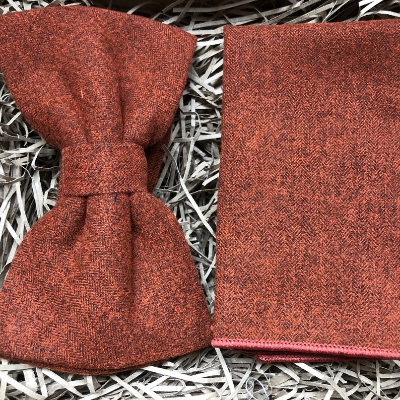 A photo of a burnt orange, cotton mens bow tie and a matching pocket square ideal for weddings