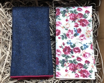 Può includere: Due fazzoletti da taschino, uno blu navy con bordo rosso e uno bianco con un motivo floreale in tonalità di rosso, rosa e blu.