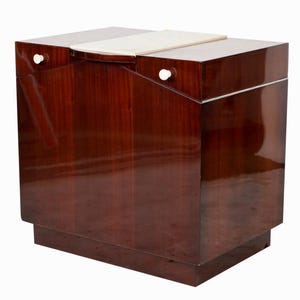 Puede incluir: Un gabinete de madera de caoba con una tapa de mármol blanco y dos pomos blancos. El gabinete tiene un diseño elegante y moderno y es perfecto para guardar objetos de forma elegante.