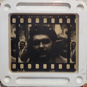 Könnte beinhalten: Ein Schwarzweißfoto eines Männergesichts, gerahmt in einem weißen Plastik-Dia-Mount. Der Dia-Mount hat den Text "HS EKtachrome FILM" und die Zahlen "27A" und "28" aufgedruckt.