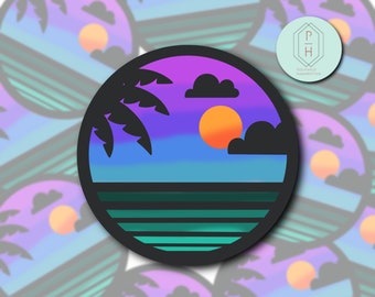 Puede incluir: Una pegatina circular que muestra una puesta de sol sobre el océano con la silueta de una palmera a la izquierda y nubes oscuras. El cielo cambia de violeta a azul, mientras que el agua tiene rayas horizontales en tonos verde oscuro y azul verdoso.