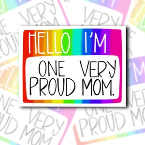 May include: A rainbow-colored sticker with the text "Hello I'm One Very Proud Mom." The sticker is in the shape of a name tag.