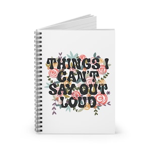 May include: A white spiral notebook with a floral design and the text "Things I Can't Say Out Loud".