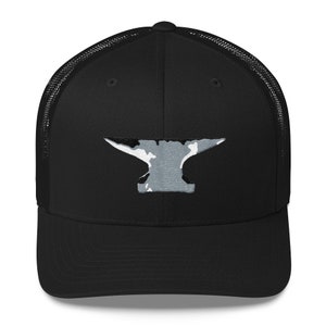 May include: Black trucker hat featuring a gray and white anvil design on the front. The hat has a mesh back and a curved brim. The anvil graphic is centered and has a distressed, camouflage-like pattern.