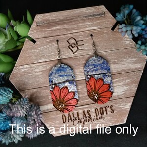 Peut inclure: Une paire de boucles d'oreilles pendantes avec un fond argenté et bleu et un motif de fleur rouge. Les boucles d'oreilles sont sur un présentoir en bois avec le texte "Dallas Dot's Emporium" et "Ceci est un fichier numérique uniquement".