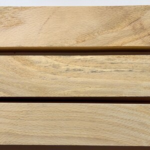 Puede incluir: Tres piezas de madera de color marr&oacute;n claro, apiladas una encima de la otra. La madera tiene un patr&oacute;n de veta natural.