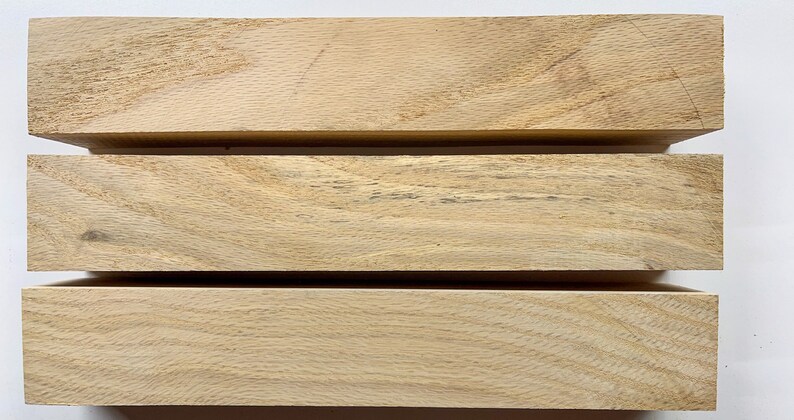 Puede incluir: Tres piezas de madera de color marr&oacute;n claro, apiladas una encima de la otra. La madera tiene un patr&oacute;n de veta natural.