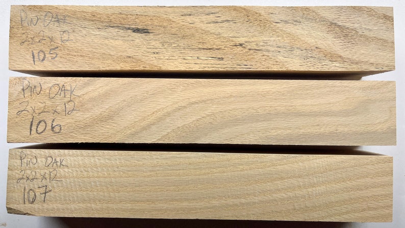 Puede incluir: Tres piezas de madera de pino roble sin terminar, cada una mide 5,1 x 5,1 x 30,5 cm. La madera es de color marr&oacute;n claro y tiene un patr&oacute;n de veta natural. Las piezas est&aacute;n etiquetadas con los n&uacute;meros 105, 106 y 107.