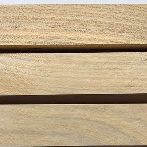 Puede incluir: Tres piezas de madera de color marr&oacute;n claro, apiladas una encima de la otra. La madera tiene un patr&oacute;n de veta natural.