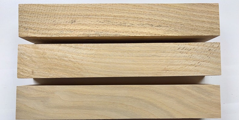 Puede incluir: Tres piezas de madera de color marr&oacute;n claro, apiladas una encima de la otra. La madera tiene un patr&oacute;n de veta natural.