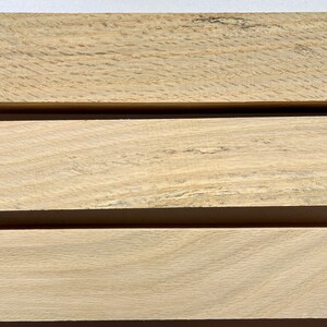 Puede incluir: Tres piezas de madera de color marr&oacute;n claro, apiladas una encima de la otra. La madera tiene un patr&oacute;n de veta natural.