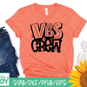 May include: A coral pink t-shirt with the text "VBS GROW" in black lettering. The text is in a stylised, bubble-like font.