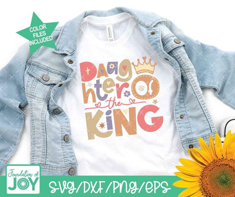 May include: A white t-shirt with the text "Daughter of the King" in colorful letters with a crown and hearts. The shirt is on a denim jacket and a sunflower.