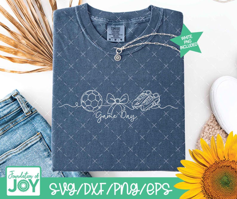 May include: A blue t-shirt featuring a white outline design of a football, bow, and football boots, with the text "Game Day". The shirt has a Comfort Colors label and a silver necklace. A green star with "White PNG Included" is also visible.