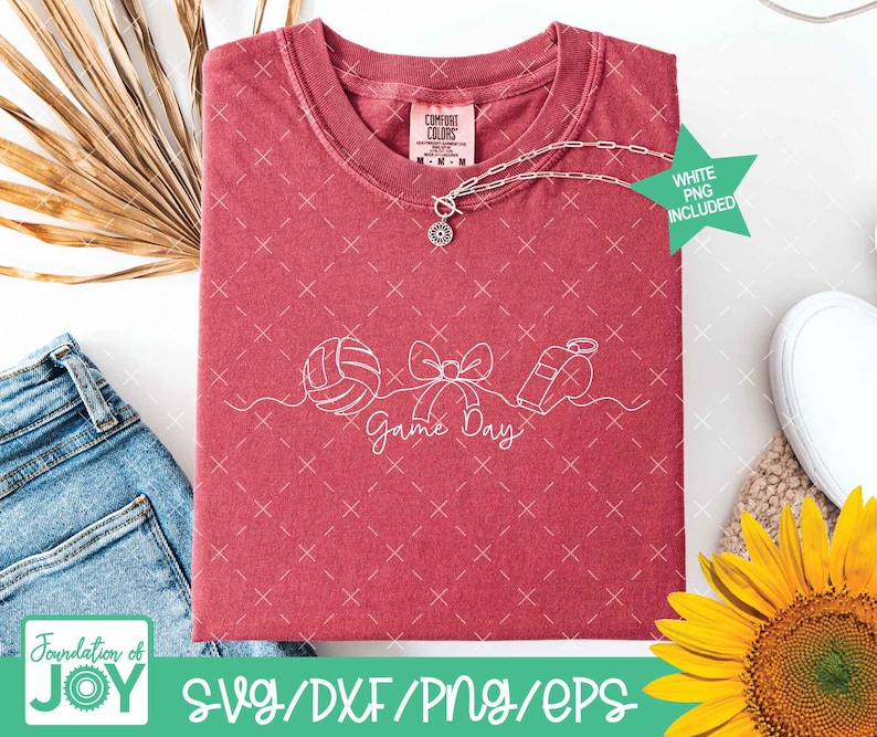 May include: A red t-shirt with a white graphic of a volleyball, bow, and whistle, with the words "Game Day." A silver necklace with a pendant is on the shirt. A green star indicates a white PNG is included.