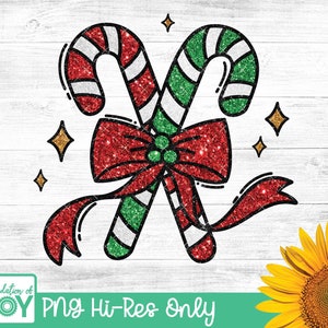 May include: Two red and green candy canes with white stripes are tied together with a red bow with green glitter. The candy canes and bow have a sparkly glitter texture.
