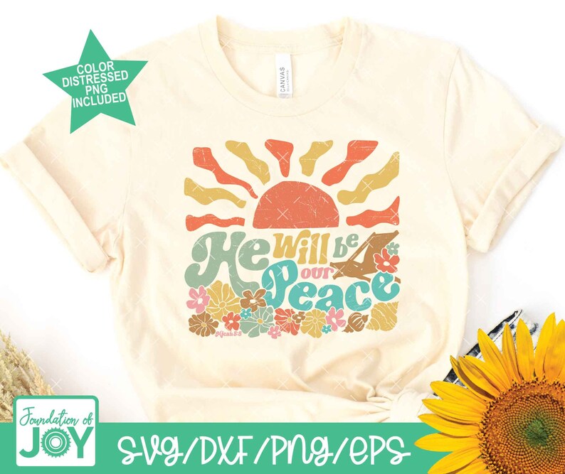 May include: A beige t-shirt with a retro-style graphic design featuring a sun, flowers, and the text "He will be our peace".
