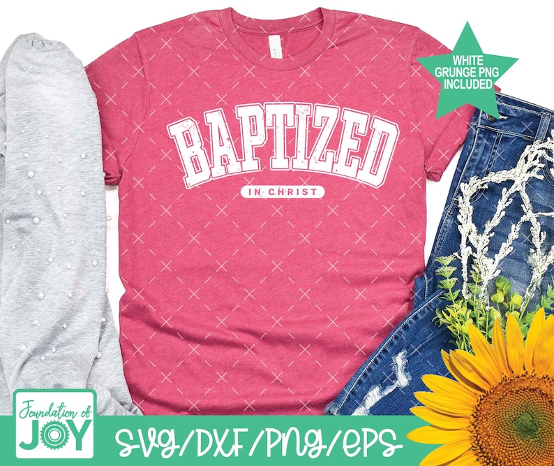 Puede incluir: Una camiseta rosa con el texto "BAPTIZED IN CHRIST" en blanco, con un PNG grunge blanco incluido. La camiseta est&aacute; sobre un fondo blanco con una camiseta gris y unos vaqueros azules con un girasol.